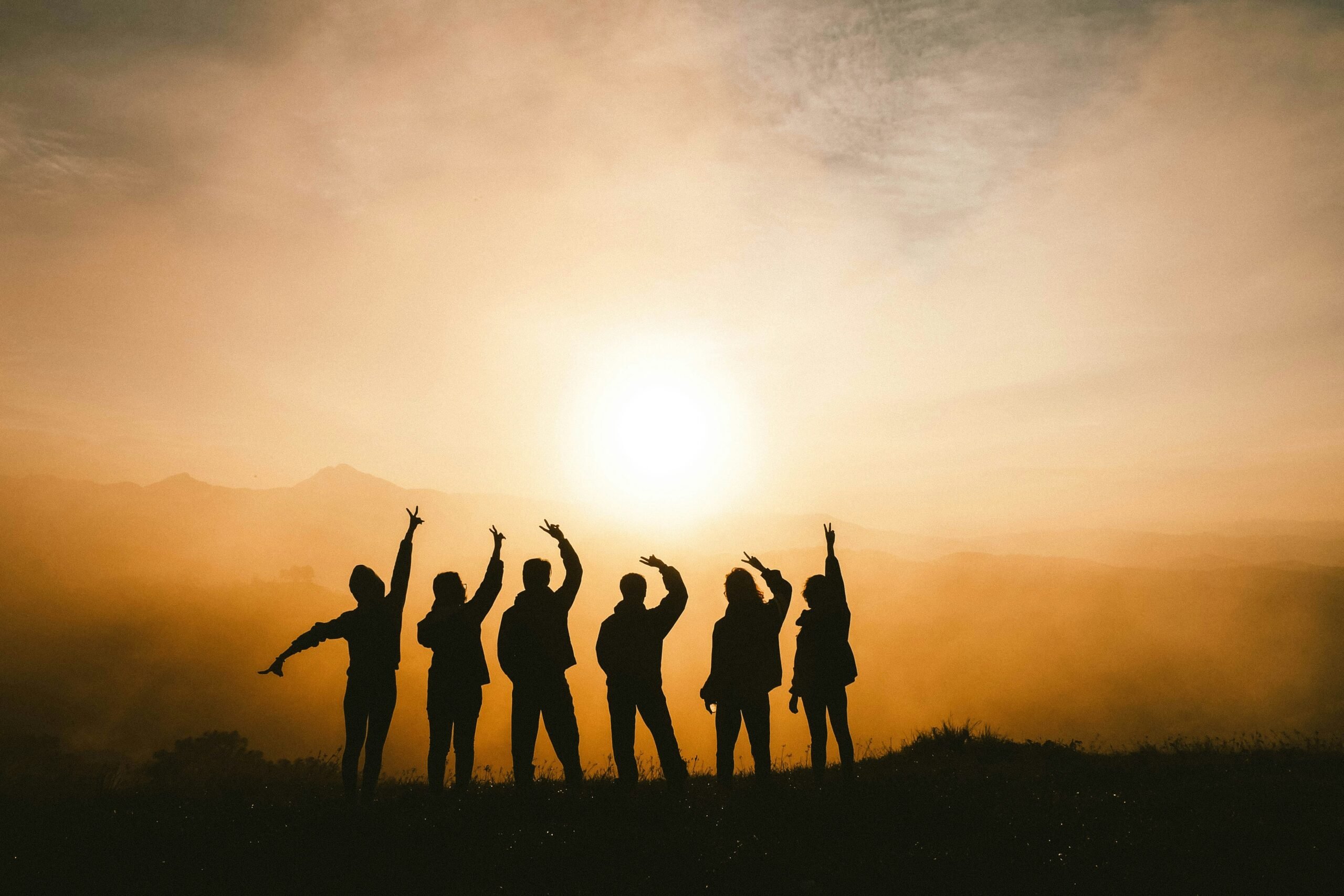 Clarksville recovery community silhouetted at sunrise, arms raised in hope and mutual support
