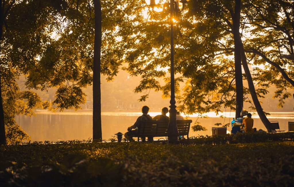 People sitting by the water at sunset on National Grief Awareness Day reflecting and supporting each other