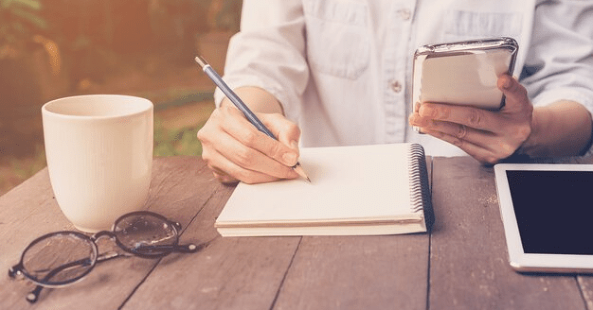 Person tracking progress in a habit journal, focusing on building healthy habits and habit stacking for a healthier lifestyle.