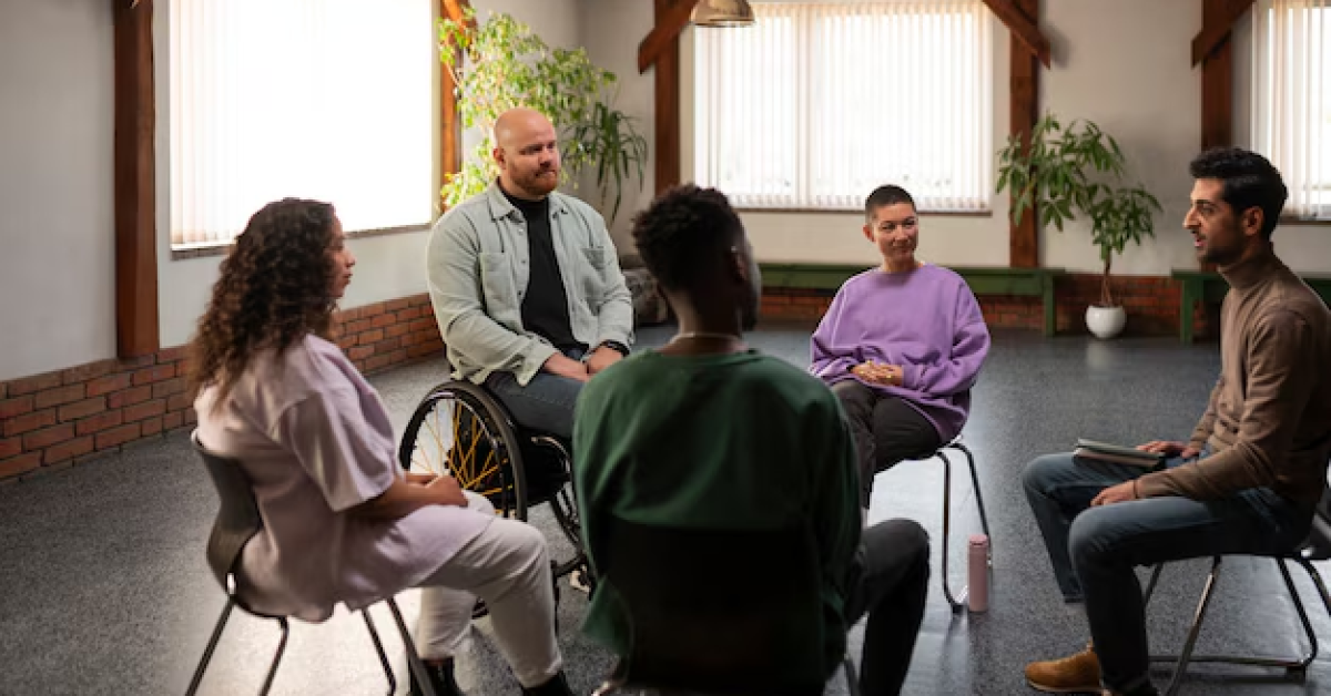 A diverse addiction recovery support group discussing myths about addiction and breaking stigma in a counseling session