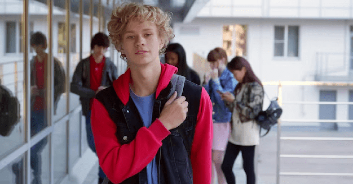 A shy student looking uncertain in a school hallway, wanting to socialize. How to make friends when you're shy and how to overcome social anxiety in school.