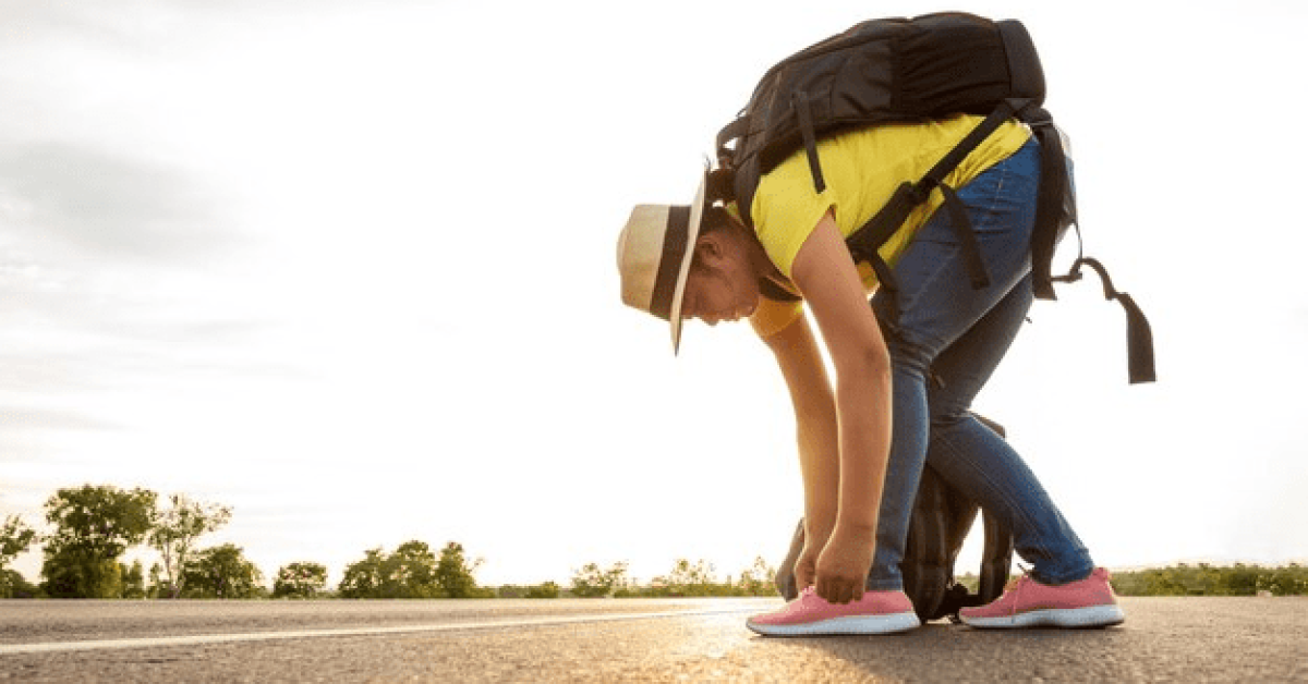 A person bending over on the road