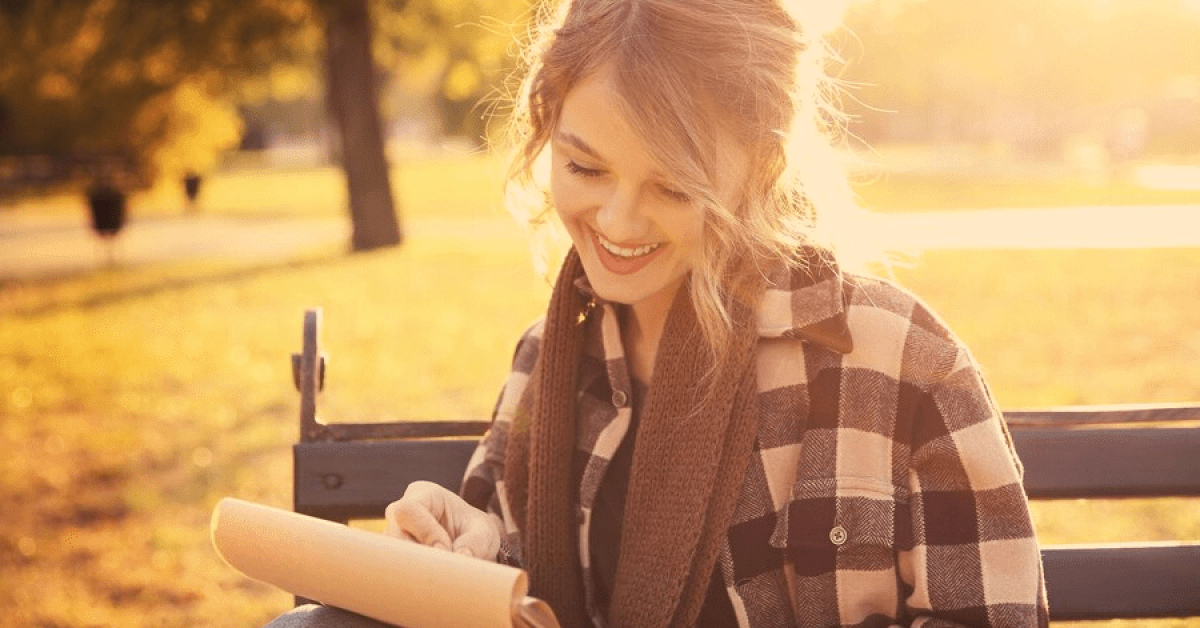A person setting SMART goals in recovery in a notebook, reflecting on their journey toward mental health recovery
