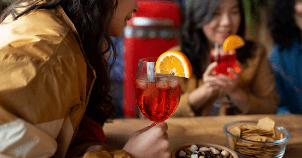 A person holding a glass of drink