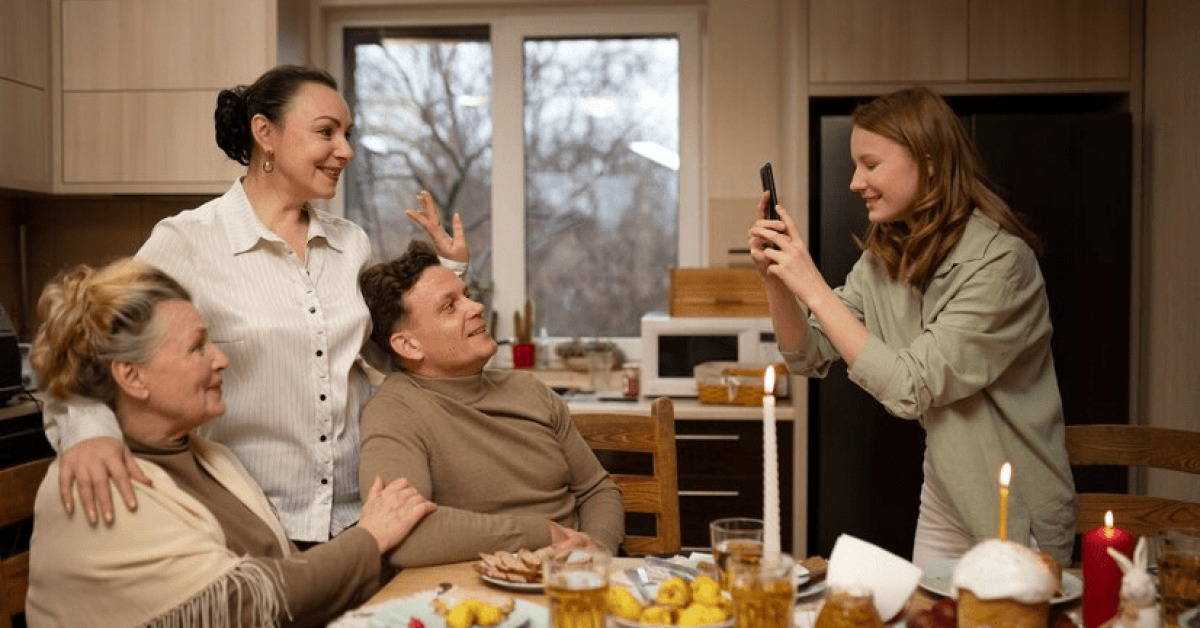 A person taking a picture of a group of people around a table
