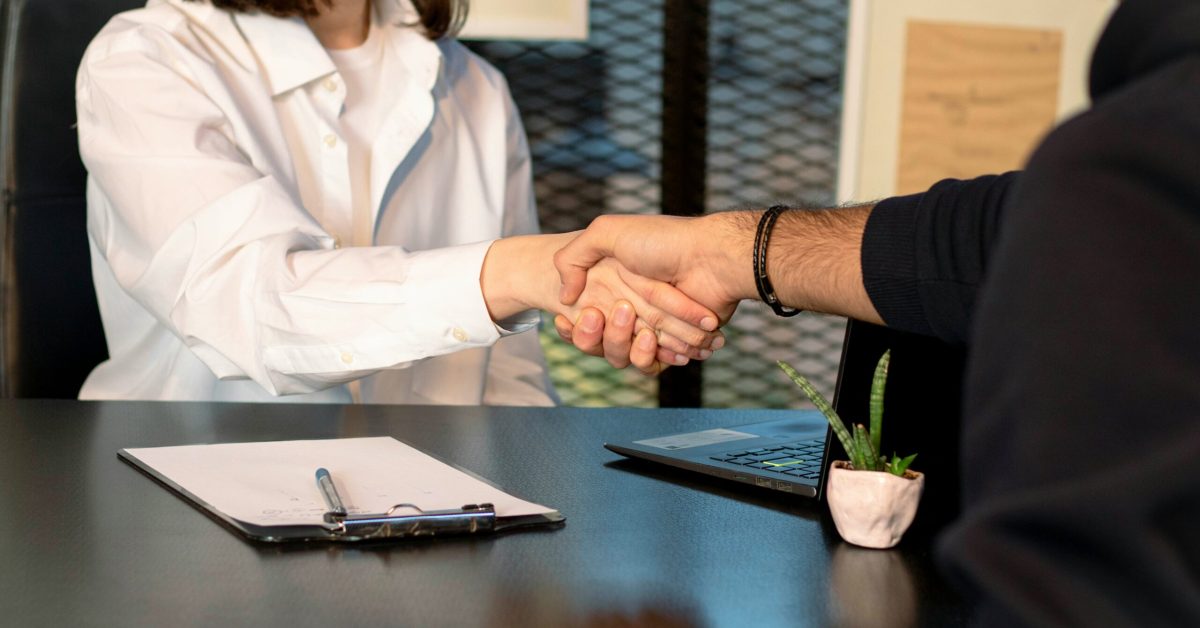 Employer shaking hands with a person in recovery during a second chance job interview