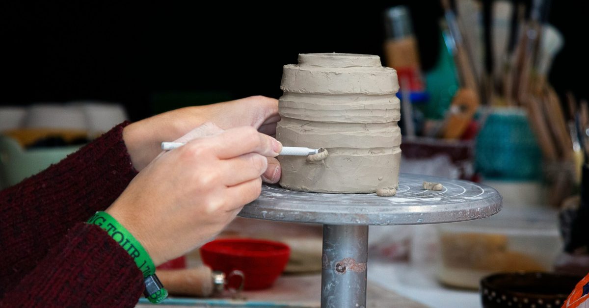 Close-up of hands sculpting clay on a pottery wheel, showcasing creative outlets in addiction recovery through art therapy.